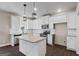 Bright kitchen features white cabinets, stainless steel appliances, and a stylish island with a granite countertop at 475 Louise Way, Locust Grove, GA 30248