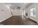 Spacious living room featuring a ceiling fan, a stone fireplace, and large windows for plenty of natural light at 475 Louise Way, Locust Grove, GA 30248