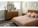 Charming bedroom featuring a dresser, a window, and decorative pillows at 4076 Airline Rd, Mcdonough, GA 30252