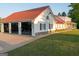Exterior view of home with detached garage, red metal roof, and lush green lawn at 4076 Airline Rd, Mcdonough, GA 30252