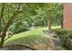 Landscaped backyard featuring a brick walkway, green grass and lush greenery at 135 Rockglen Ct, Fayetteville, GA 30215