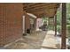 A backyard patio with a brick wall, ceiling fan, and wooded landscape offers a private retreat at 135 Rockglen Ct, Fayetteville, GA 30215