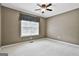 Comfortable bedroom with neutral walls, plush carpeting, and a window with privacy blinds at 135 Rockglen Ct, Fayetteville, GA 30215