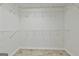 Walk-in closet with white wire shelving and tiled floors offering ample storage space and organization at 135 Rockglen Ct, Fayetteville, GA 30215