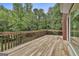 A spacious wooden deck with railings offers a relaxing outdoor living space surrounded by lush greenery at 135 Rockglen Ct, Fayetteville, GA 30215