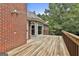 A wide wooden deck offers an outdoor space with room to entertain, attached to brick house at 135 Rockglen Ct, Fayetteville, GA 30215