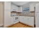 Kitchen features white cabinets, tiled backsplash, and modern appliances in a well-lit space at 488 N Jeff Davis Dr, Fayetteville, GA 30214