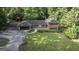 Aerial shot of brick home featuring a lush lawn, mature trees, and a convenient attached two-car garage at 23 Hunting Creek Dr, Marietta, GA 30068