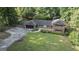 Aerial view of a brick home with a well-manicured lawn, mature trees, and an attached garage at 23 Hunting Creek Dr, Marietta, GA 30068