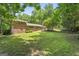 Expansive brick home with a lush green backyard and mature trees on a sunny day at 23 Hunting Creek Dr, Marietta, GA 30068