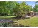 Spacious backyard with a lush lawn, mature trees, and a patio with outdoor seating at 23 Hunting Creek Dr, Marietta, GA 30068