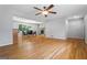 Open-concept living room with hardwood floors, a ceiling fan, a fireplace, and adjacent dining area at 23 Hunting Creek Dr, Marietta, GA 30068