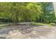 Concrete back patio area with table and chairs, mature trees, and landscaping at 23 Hunting Creek Dr, Marietta, GA 30068
