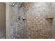 Close up on the travertine shower with dual shower heads and built-in shelves in this updated bathroom at 23 Hunting Creek Dr, Marietta, GA 30068