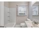 Well-lit bathroom featuring a bathtub with tiled surround, a vanity with a sink, and a toilet at 1318 Beecher Sw St, Atlanta, GA 30310