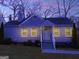 Inviting home exterior with warm lighting and a well-maintained lawn, providing a cozy nighttime ambiance at 1318 Beecher Sw St, Atlanta, GA 30310