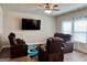 Cozy living room with leather seating, ceiling fan, and large windows at 340 Mcgiboney Ln, Covington, GA 30016