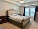 This bedroom features a tray ceiling, carpet, and a large window with blinds at 340 Mcgiboney Ln, Covington, GA 30016