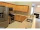 Bright kitchen with stainless appliances, light wood cabinets, open floor plan view to living area at 175 Camry Ln, Grayson, GA 30017