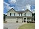 Two-story home with light-blue siding, black shutters, three-car garage, and well-maintained landscaping at 9108 Alden Dr, Locust Grove, GA 30248