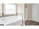 Bright, spacious bathroom with a large tub and tiled surround next to a shower stall at 9046 Holder Rd, Locust Grove, GA 30248