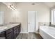 Bathroom showcasing double vanity, granite counters, stylish lighting, and separate tub at 9046 Holder Rd, Locust Grove, GA 30248