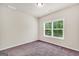 Cozy bedroom with plush carpeting and a window overlooking lush greenery, offering tranquility at 9046 Holder Rd, Locust Grove, GA 30248
