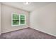 Neutral bedroom featuring a large window offering natural light and plush carpeting at 9046 Holder Rd, Locust Grove, GA 30248