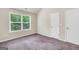 Bedroom featuring plush carpeting and a window overlooking lush trees, perfect for relaxing at 9046 Holder Rd, Locust Grove, GA 30248