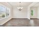 Spacious dining room with hardwood floors, a chandelier, and large windows offering natural light at 9046 Holder Rd, Locust Grove, GA 30248