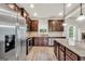 Spacious kitchen featuring stainless steel appliances, dark wood cabinets, and a granite island at 9046 Holder Rd, Locust Grove, GA 30248