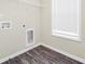 Empty laundry room with hookups, shelving, window, and plank flooring at 9046 Holder Rd, Locust Grove, GA 30248