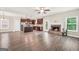 Open-concept living room with a fireplace next to kitchen with stainless steel appliances at 9046 Holder Rd, Locust Grove, GA 30248