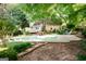 Lush backyard featuring a swimming pool, patio area, mature trees, and a well-manicured lawn at 110 Orchard Vw, Fayetteville, GA 30215