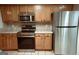 Well-lit kitchen featuring stainless appliances, oak cabinets, and a tile backsplash, seamlessly blending style and functionality at 110 Orchard Vw, Fayetteville, GA 30215