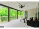 Covered deck with ceiling fan and comfortable seating overlooks green trees at 120 Lapis Lake Pt, Fayetteville, GA 30215
