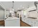 Well-lit kitchen with white cabinetry, stainless steel appliances, and a large island with pendant lighting at 120 Lapis Lake Pt, Fayetteville, GA 30215