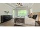 Serene main bedroom boasts a tray ceiling, large window, and stylish dark wood dresser at 120 Lapis Lake Pt, Fayetteville, GA 30215