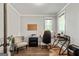 Well-lit home office features hardwood floors, modern desk, comfortable chair, and serene window view at 120 Lapis Lake Pt, Fayetteville, GA 30215