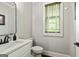Elegant powder room features sleek vanity, stylish mirror, and natural light from a window at 120 Lapis Lake Pt, Fayetteville, GA 30215