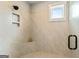 Tiled shower with a built-in niche, corner seat, and window offering natural light at 120 Lapis Lake Pt, Fayetteville, GA 30215