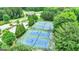 Overhead view of multiple outdoor tennis courts for recreational use with lush landscaping and mature trees at 120 Lapis Lake Pt, Fayetteville, GA 30215