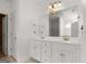 Well-lit bathroom featuring dual sinks, a large mirror, and modern fixtures at 474 Strawberry Walk, Loganville, GA 30052