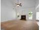 Spacious living room with a fireplace, ceiling fan, and large windows with natural light at 474 Strawberry Walk, Loganville, GA 30052