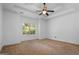 Bright main bedroom with tray ceiling, fan, and large windows at 474 Strawberry Walk, Loganville, GA 30052