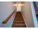 Carpeted staircase featuring a wood handrail, connecting the levels of the home at 474 Strawberry Walk, Loganville, GA 30052