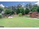 Spacious backyard with lush green grass, a charming wooden shed, and well-maintained landscaping at 2256 Long Bow Chase Nw, Kennesaw, GA 30144