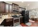 Well-lit kitchen with stainless steel appliances, granite countertops, and dark wood cabinets at 2256 Long Bow Chase Nw, Kennesaw, GA 30144