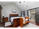 Comfortable bedroom with wood floors, accent wall, barn doors, and a door to the patio at 2256 Long Bow Chase Nw, Kennesaw, GA 30144