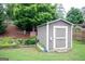 Outdoor storage shed surrounded by flower beds, trees, and an American flag accenting the yard at 2256 Long Bow Chase Nw, Kennesaw, GA 30144